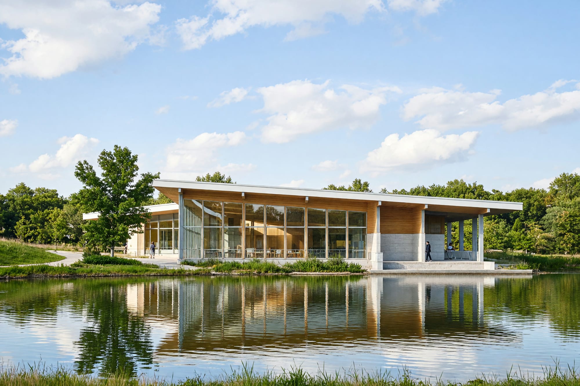 The building seen across water on a bright afternoon with a clean reflection