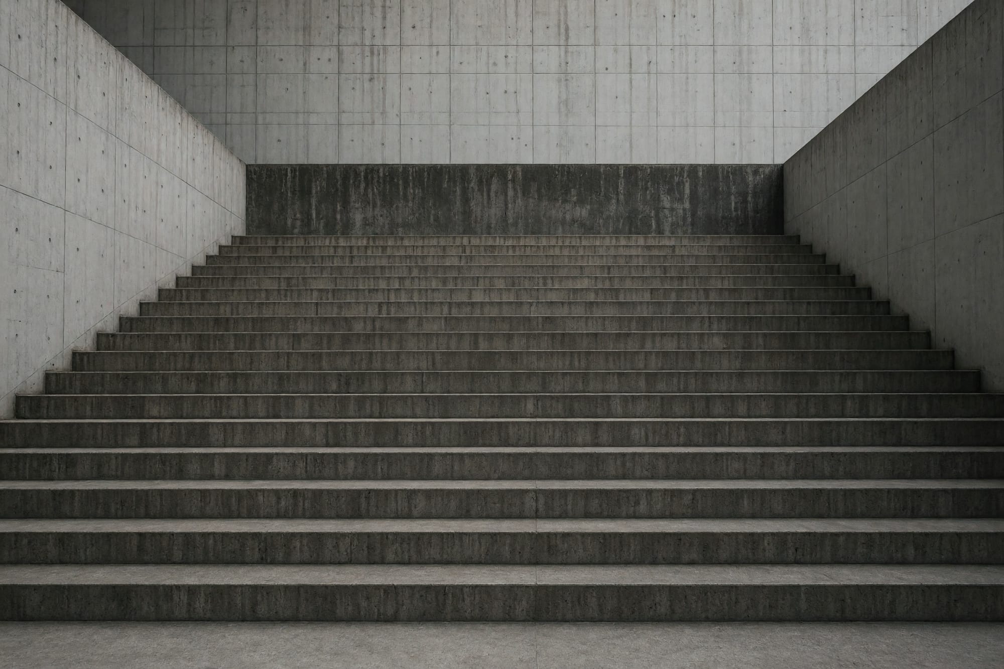 An empty amphitheatre of concrete steps seen from above at an oblique